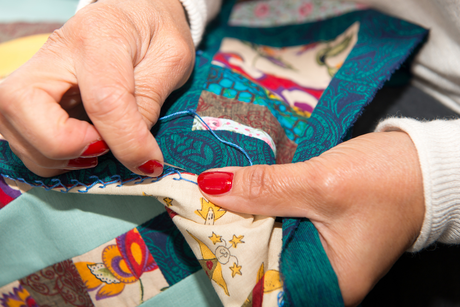 seamstress woman sewing for finish a quilt.